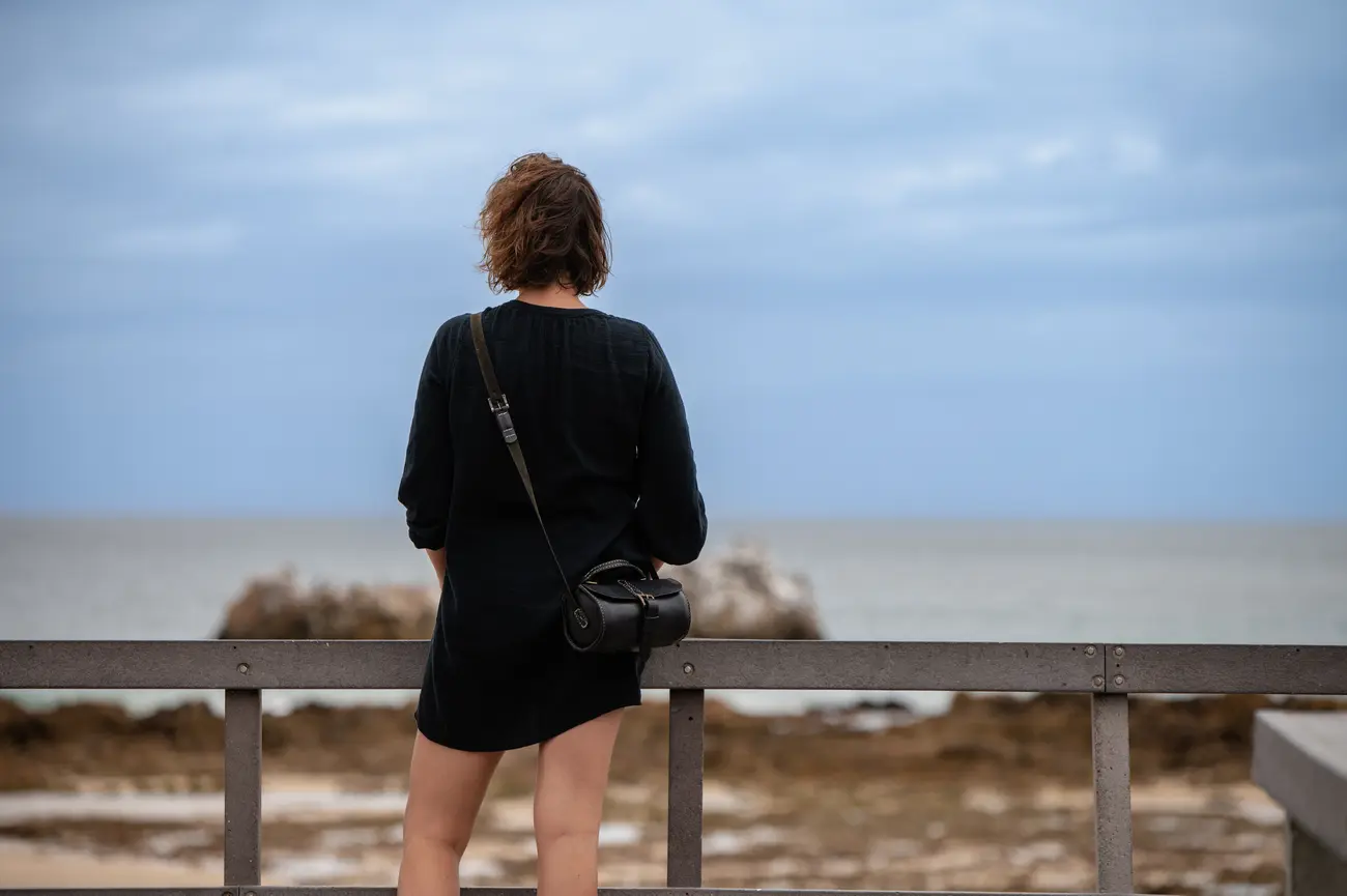 woman standing and watching the beach 2023 11 27 05 21 07 utc