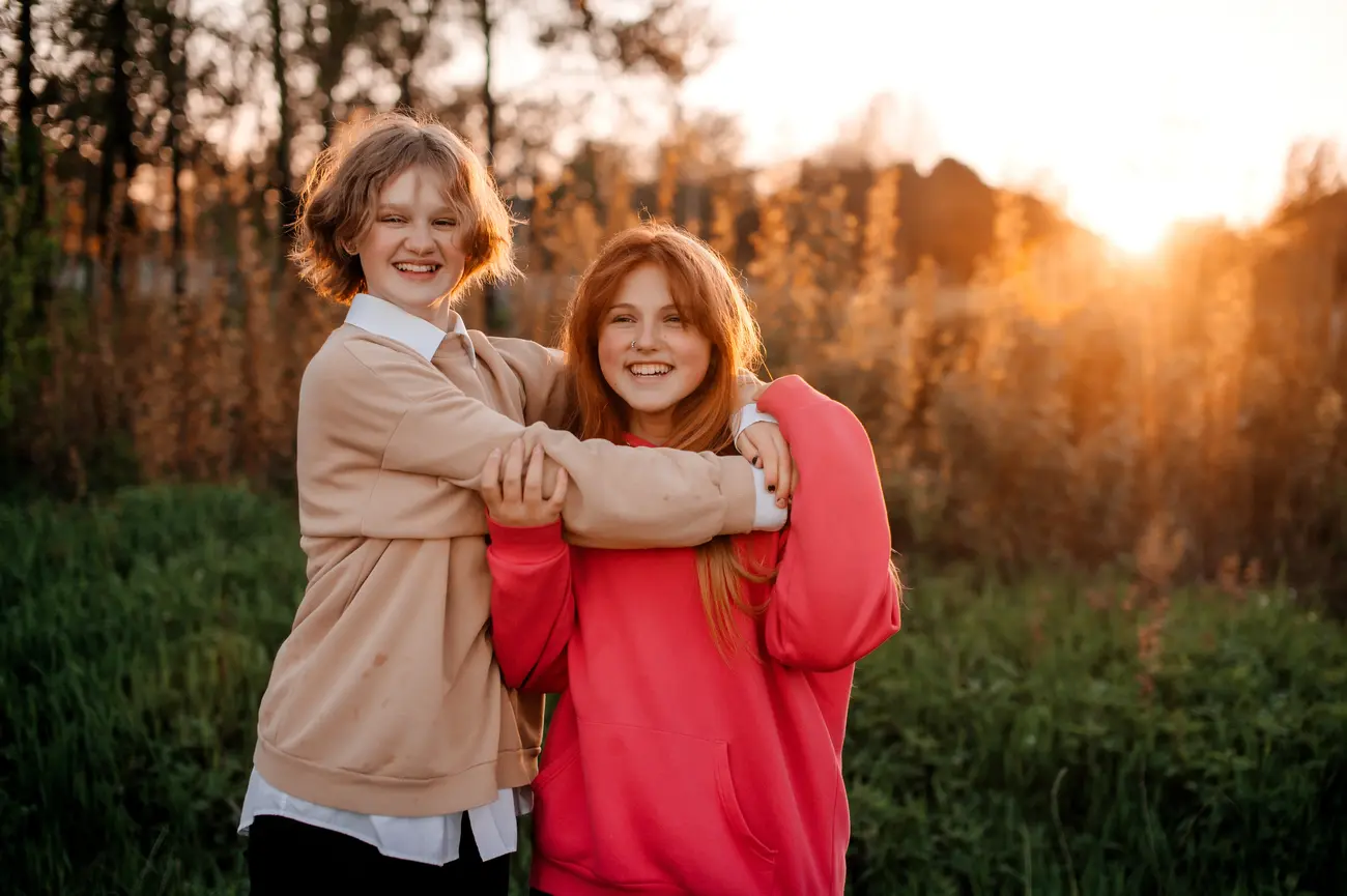 two teenage girls are hugging at sunset and laughi 2023 11 27 05 24 08 utc